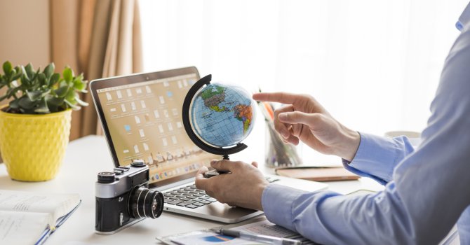 crop-man-pointing-globe-office